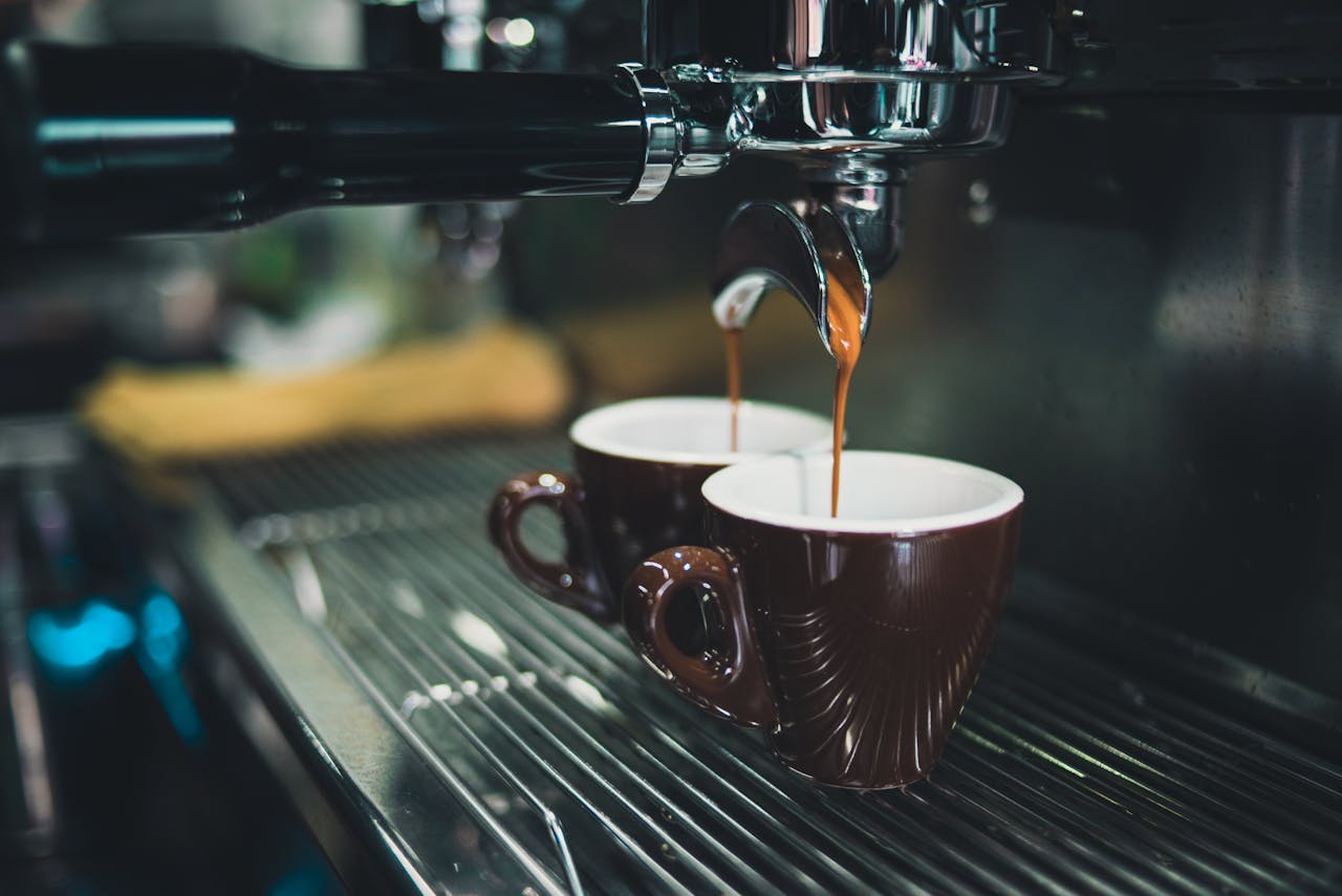 Espresso läuft in zwei Espressotassen